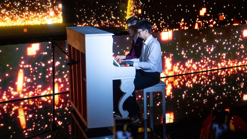 智能仿生手使用者古月與少年鋼琴家舒海峰合奏。主辦方供圖